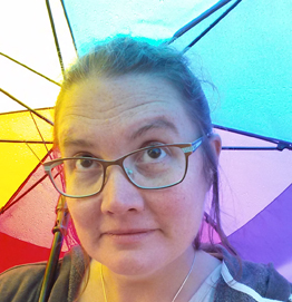 photo of founder and director April Hoff under a rainbow umbrella